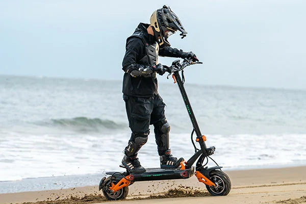 FREEBOY electric scooter rider riding along seaside beach shore